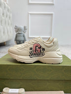 Light beige lace-up sneakers with large Gucci logo graphic on side