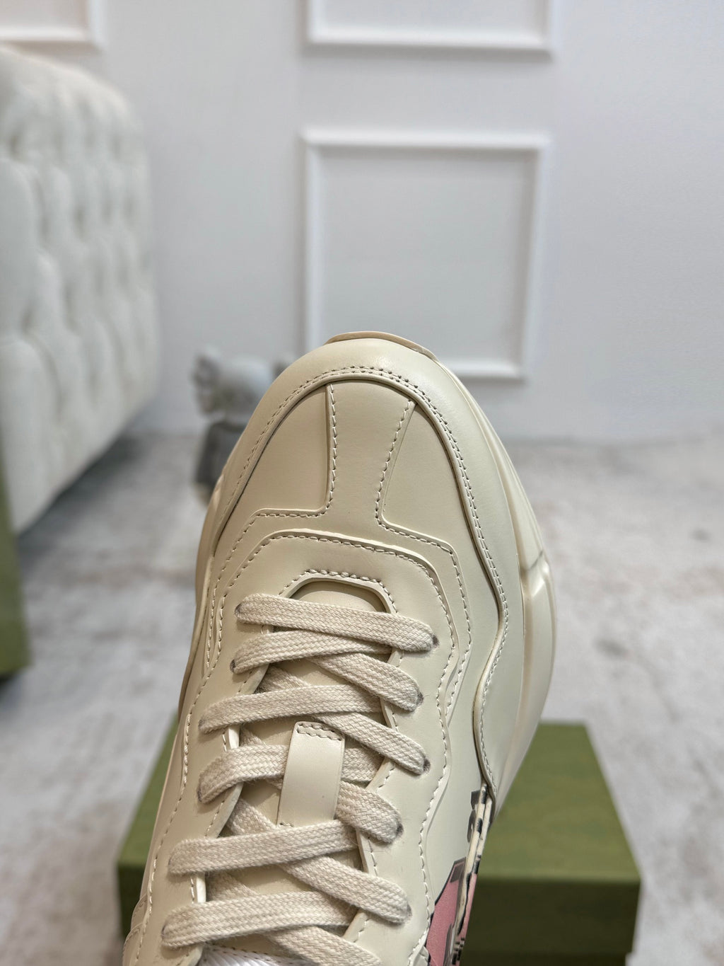 Light beige lace-up sneaker front with visible stitching and eyelets