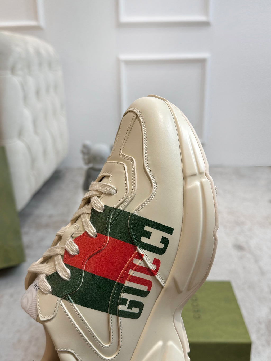 Gucci unisex sneaker close-up in cream with red and green stripe logo detail