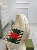 Gucci unisex sneaker close-up in cream with red and green stripe logo detail