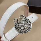 White belt close-up showing round silver floral buckle with dangling ring charms