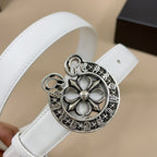 Close-up of white belt with silver flower emblem buckle and filigree edge