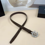 Dark brown belt with silver-toned circular floral buckle on strap