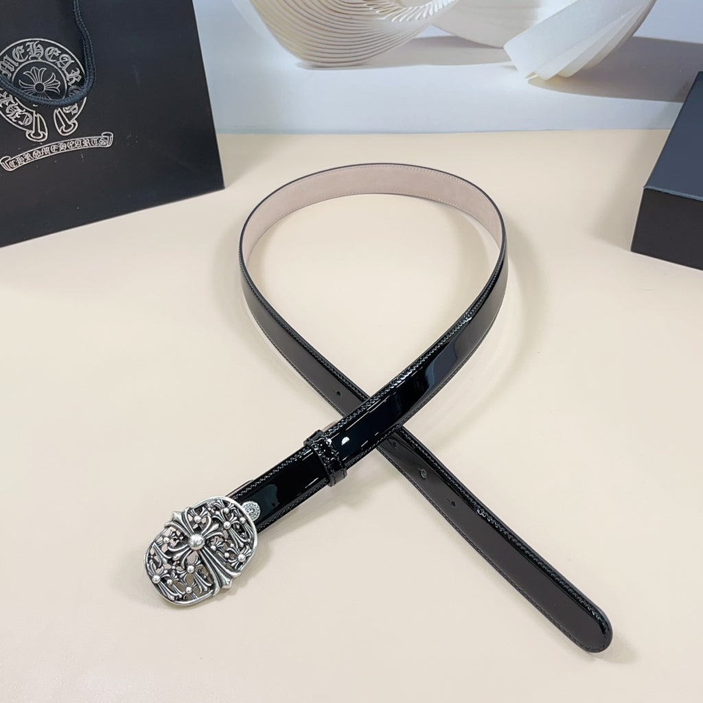 Chrome belt with black strap and ornate silver round buckle, laid flat