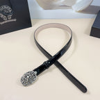 Chrome belt with black strap and ornate silver round buckle, laid flat
