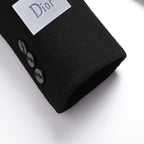 Coat cuff area with button detail and Dior-branded size tag, dark fabric
