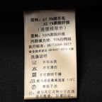 Black coat care label with fabric composition and washing instructions