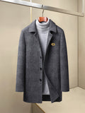 Charcoal long coat with notch lapels, button front, and small chest logo pin