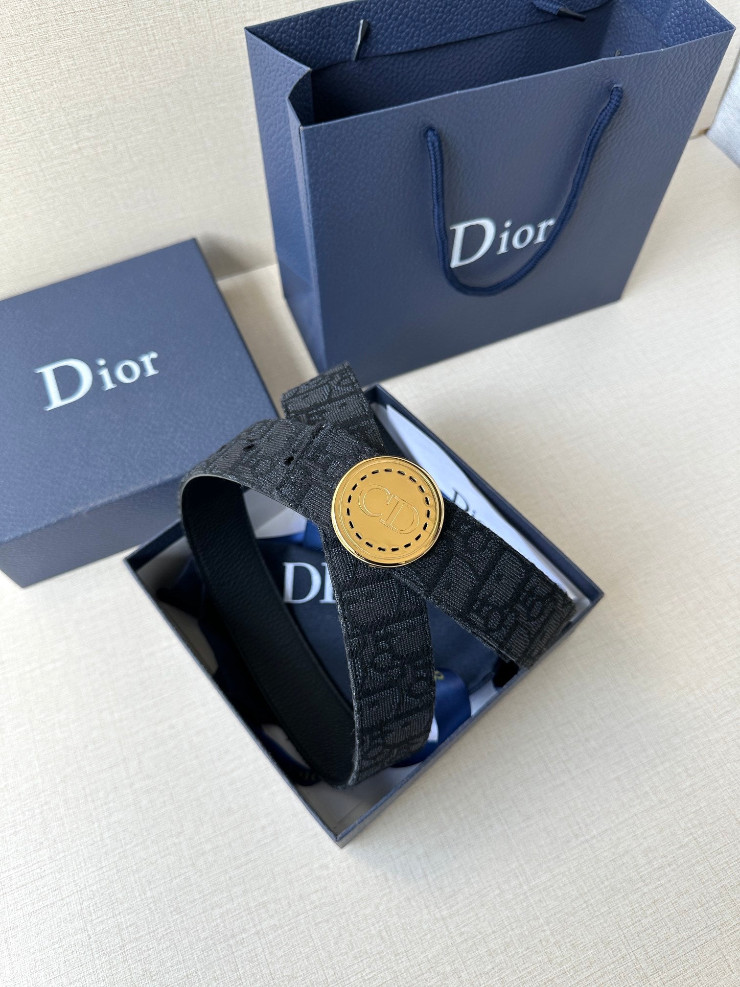 Dior belt in box with dark monogram strap and gold-tone round buckle