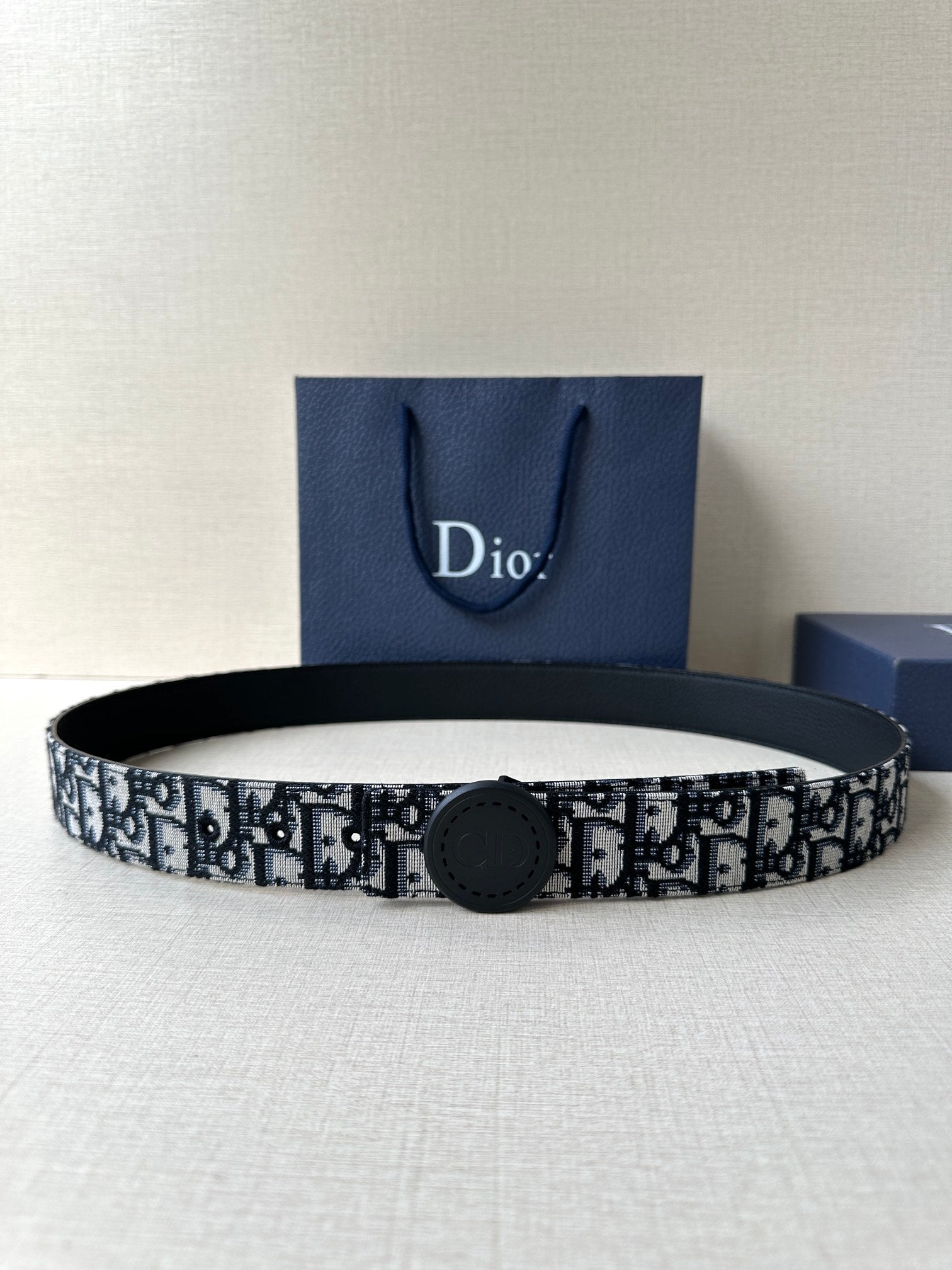 Logo-print belt with dark round buckle, black-and-white patterned strap