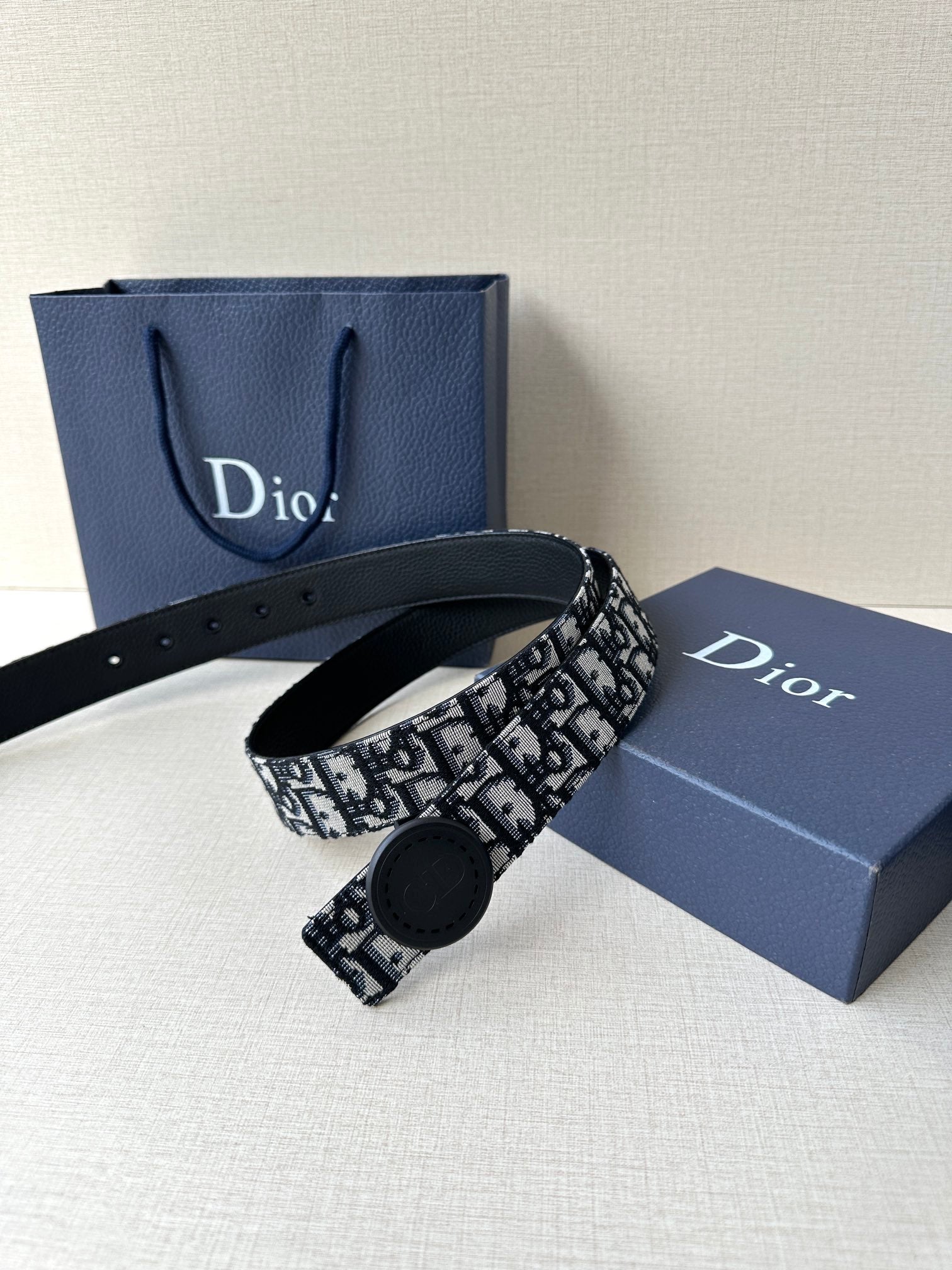 Logo-print belt with round dark buckle and black-and-white patterned strap
