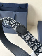 Logo-print belt close-up with round black buckle, patterned fabric strap