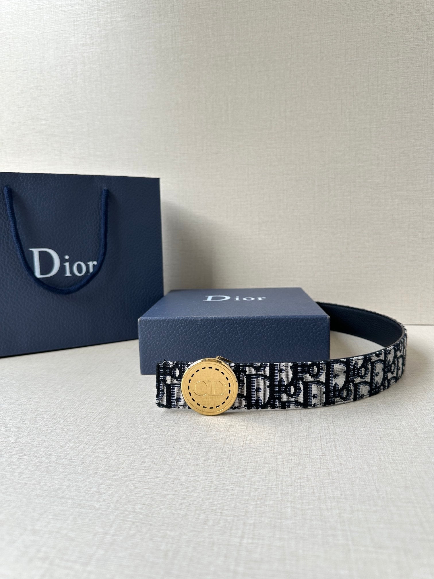 Logo-print belt with tan round buckle, dark patterned band