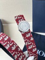 Dior belt buckle detail: white circular hardware on red-and-white monogram strap