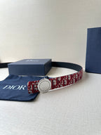 Dior belt on display; red-and-white monogram strap with white round buckle