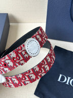 Dior belt close-up: red-and-white monogram strap with white circular buckle
