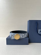 Dior belt with light blue monogram strap and round buckle, shown on a gift box