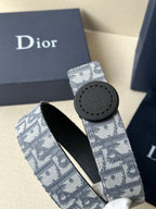Dior belt with light blue monogram strap and dark round buckle with emblem