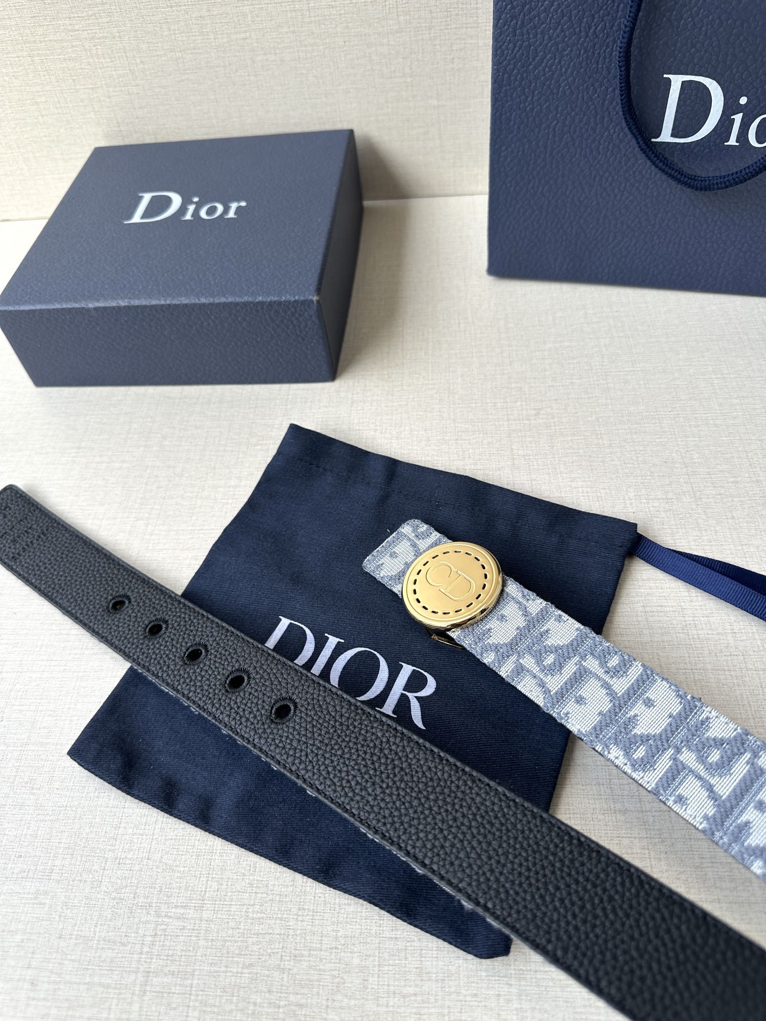 Dior belt set with textured leather strap and monogram strap, both with buckle holes