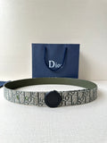 Patterned Dior belt with round black buckle and olive-green leather backing.