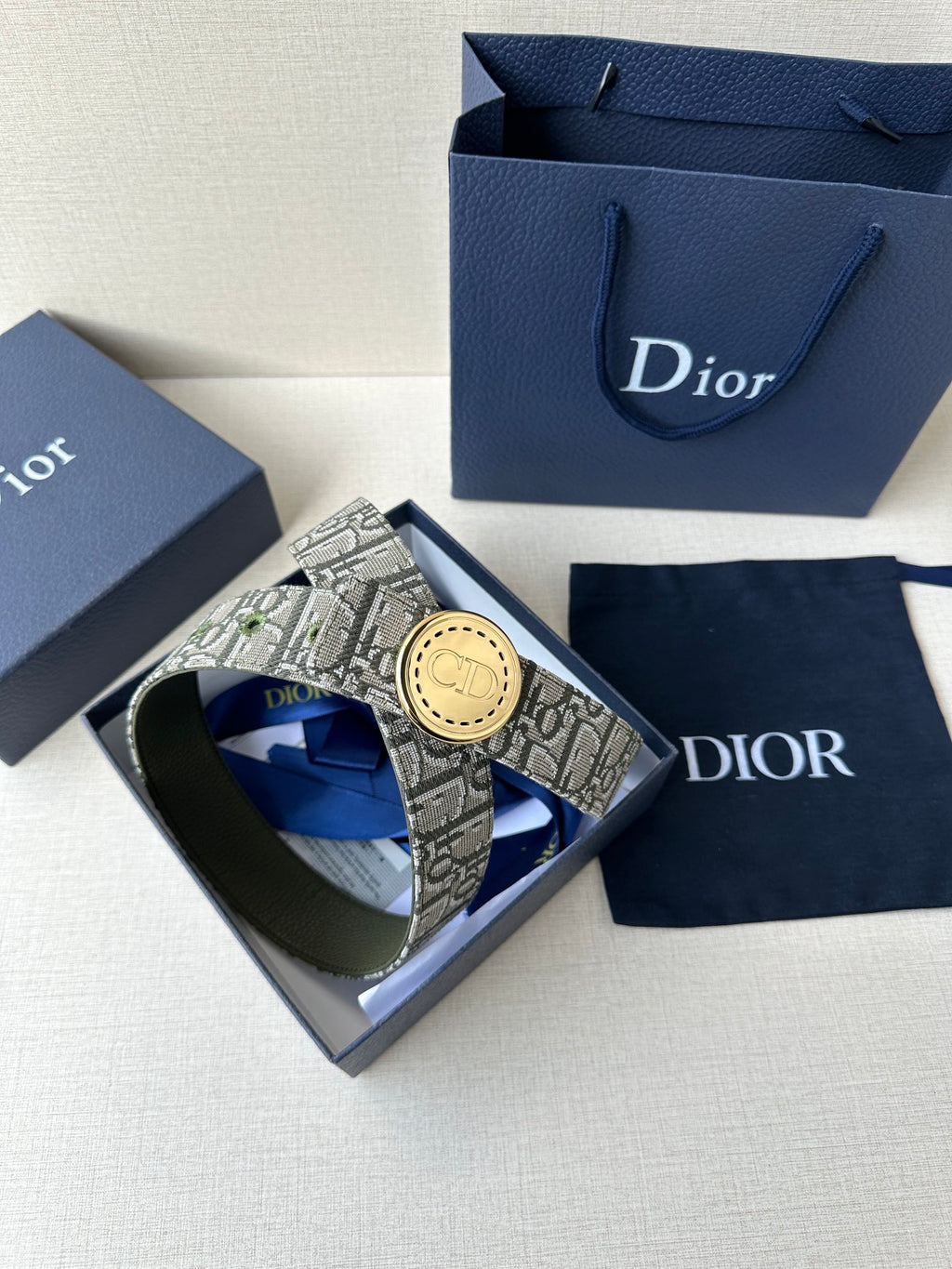 Dior belt in a gift box with monogram strap and round gold-toned buckle.