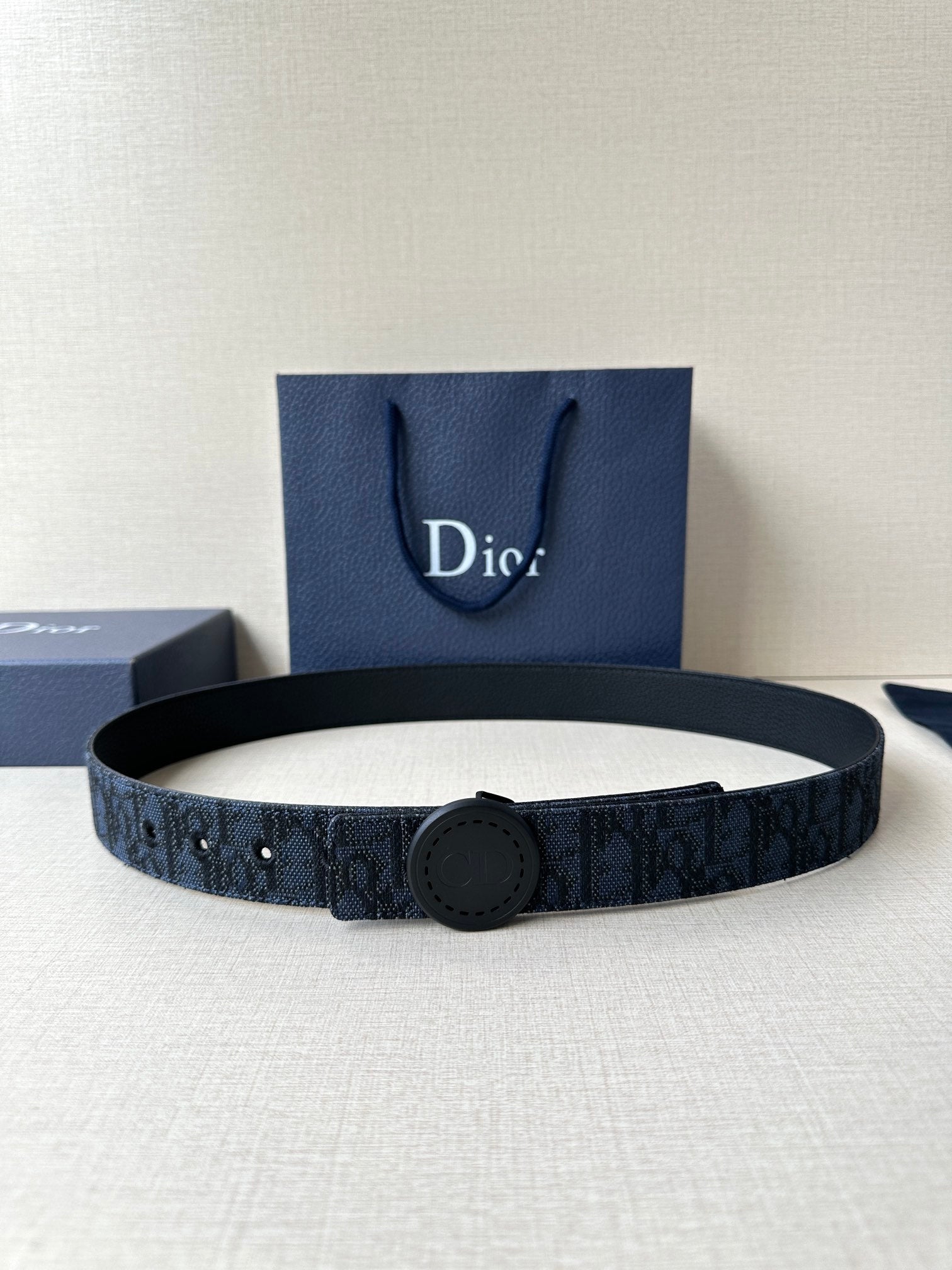 Navy Dior belt with round logo buckle and monogram-pattern strap