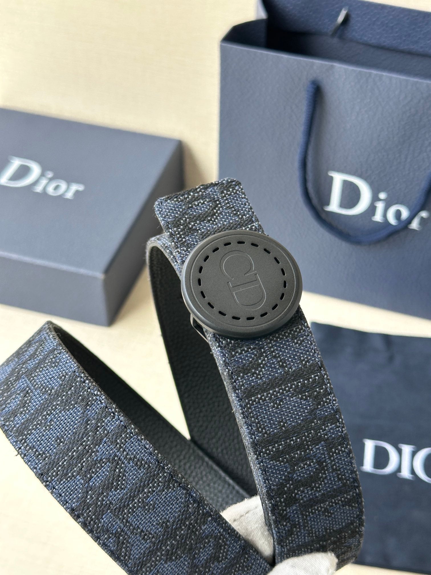 Navy Dior belt with textured monogram strap and round logo buckle