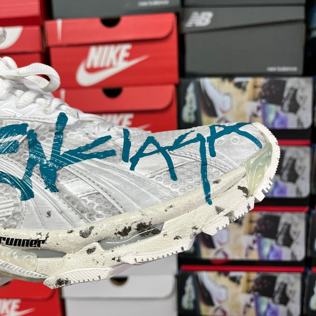 White sneaker side with blue graffiti graphic and chunky off-white sole