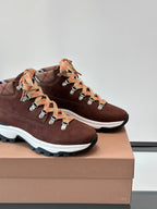 Close-up of brown suede sneakers with lace-up plaid ribbon laces and white sole edge