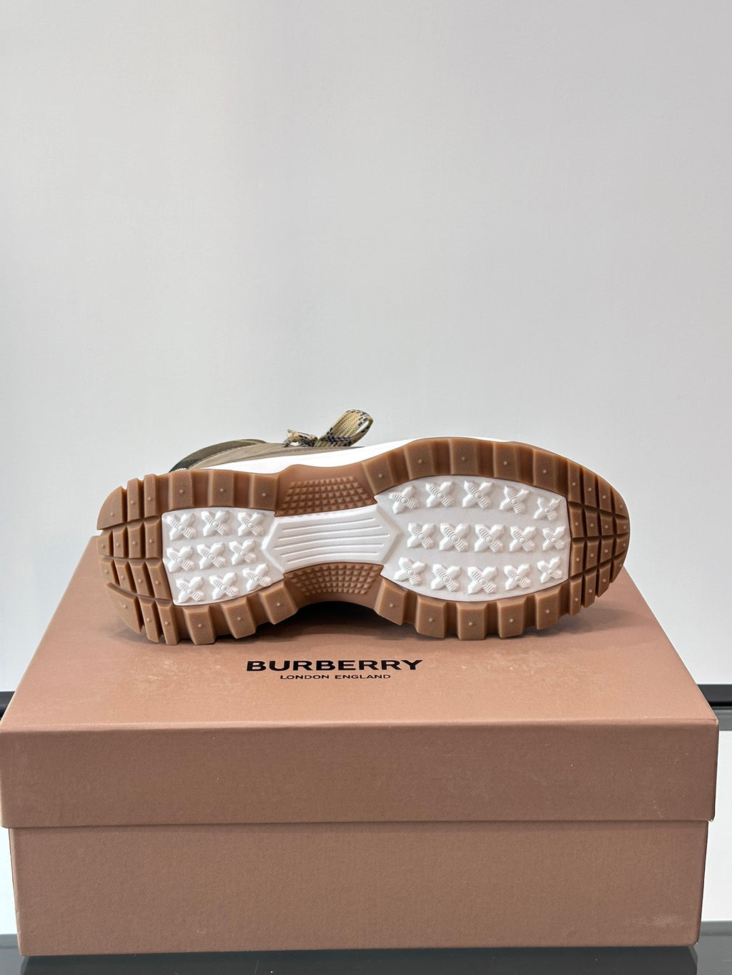 Burberry boot outsole view with grippy rubber tread, tan-brown bottom