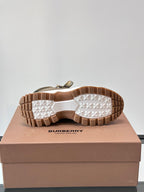 Burberry boot outsole view with grippy rubber tread, tan-brown bottom