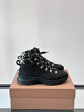 Black high-top lace-up boots with plaid-lined collar and chunky rubber sole