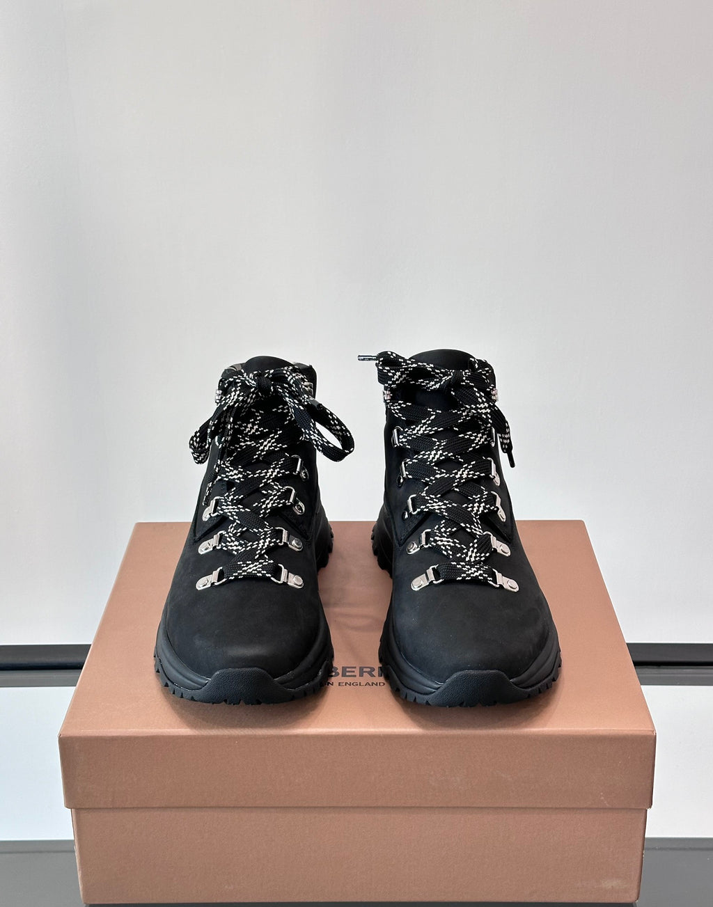Pair of black high-top lace-up boots with plaid lining and silver-tone eyelets