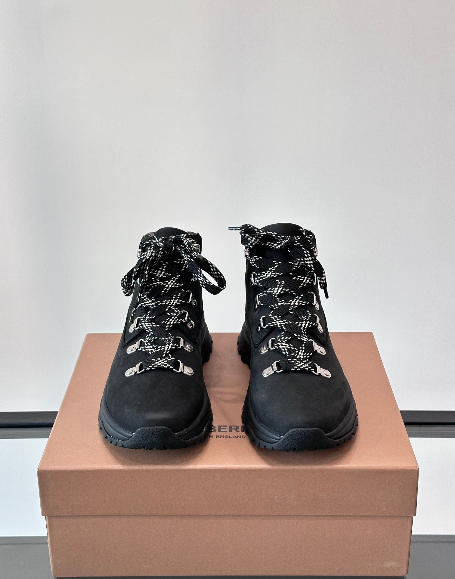 Pair of black high-top lace-up boots with plaid lining and silver-tone eyelets