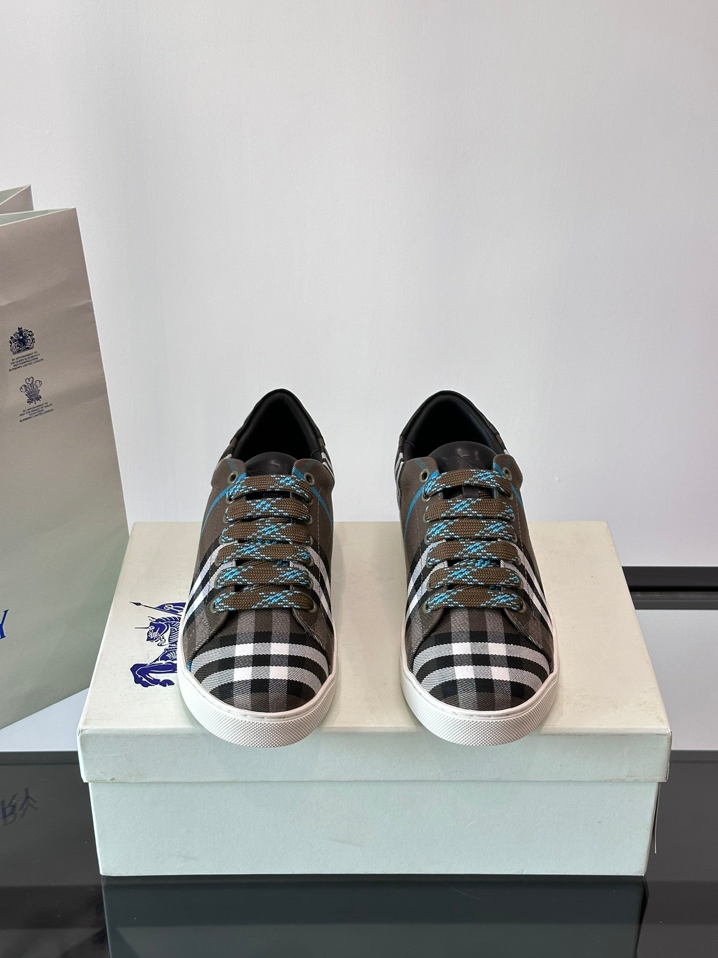 Plaid low-top sneakers, black trim, lace-up with blue accents, shown front view