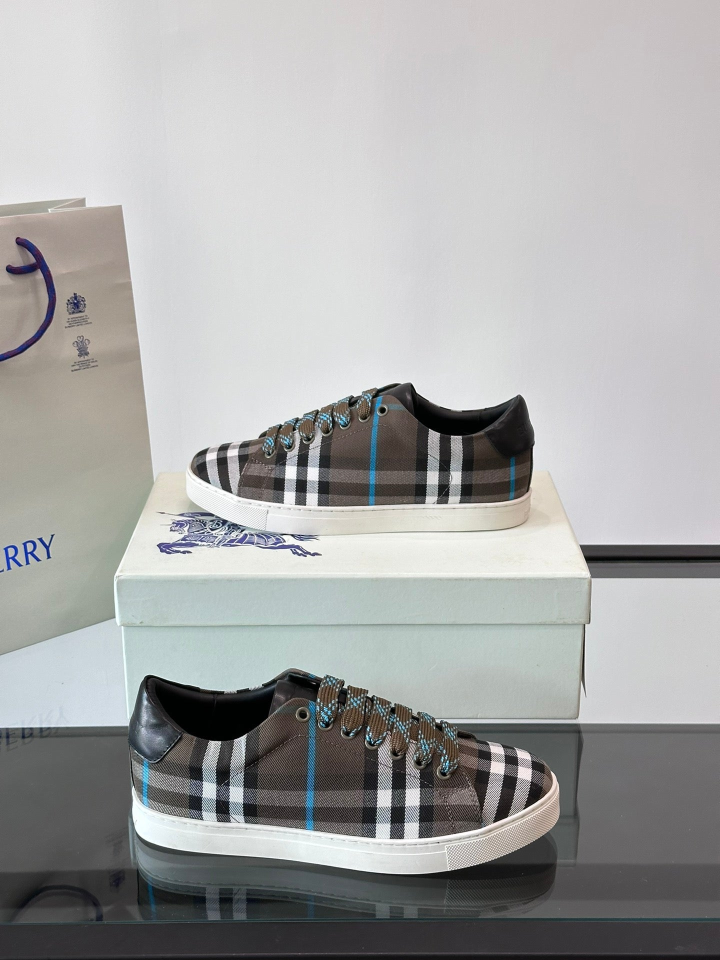 Plaid low-top sneakers, black heel and toe trim, lace-up with blue accents