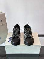 Burberry sneakers front view, black with black-and-white check laces and cap toe