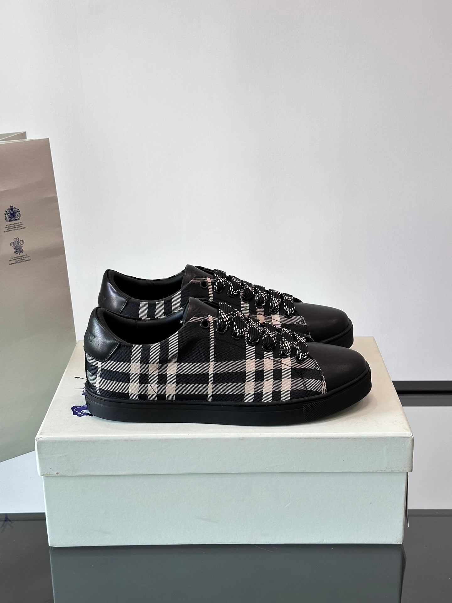 Burberry black lace-up sneakers with black-and-white check panel and fringe trim