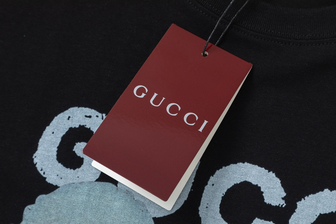 Black Gucci T-shirt close-up with red GUCCI hang tag and bear graphic