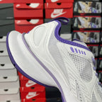 White Balenciaga sneaker with purple heel collar and lace-up front, side mesh panels