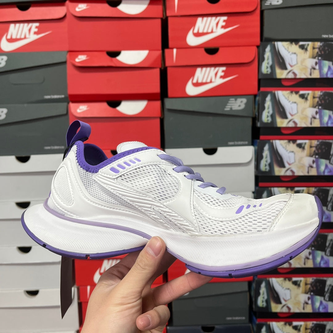 White and purple Balenciaga lace-up sneaker in hand, mesh upper and cushioned sole
