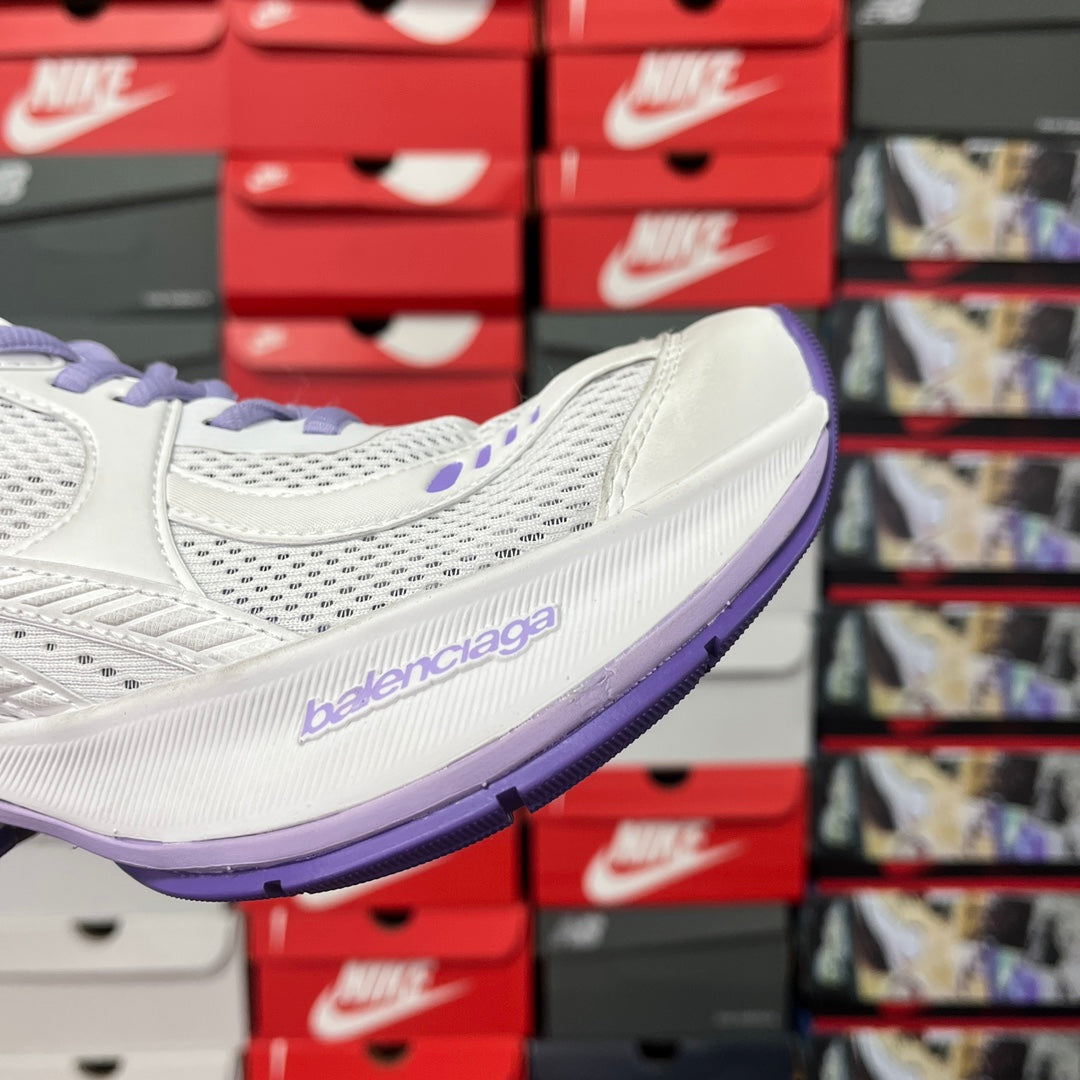 White Balenciaga sneaker side profile with purple sole edge and logo on side