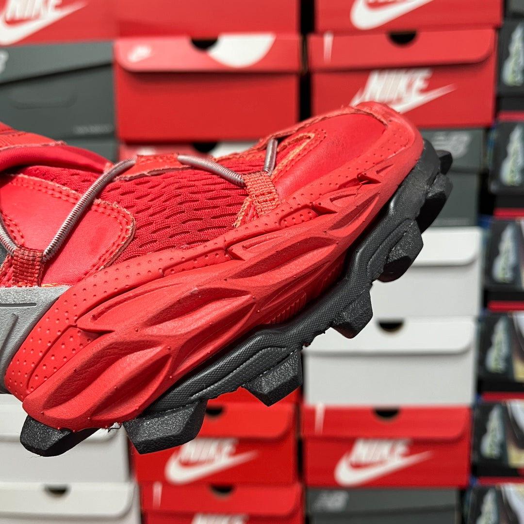Red textured sneaker upper with thick black tread sole, side angle