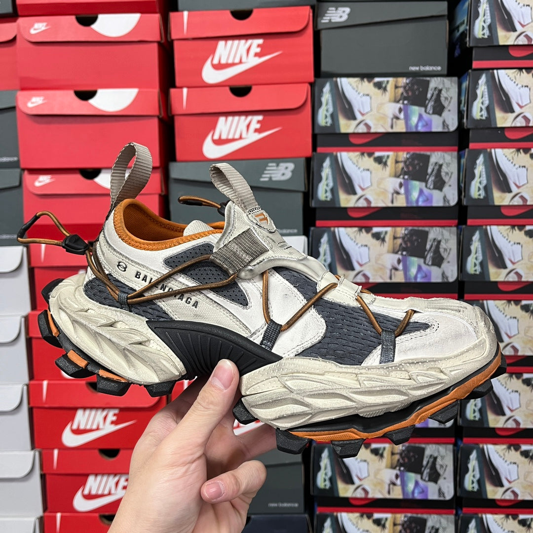 Balenciaga unisex chunky sneakers in light gray and black with orange accents, lace-up.