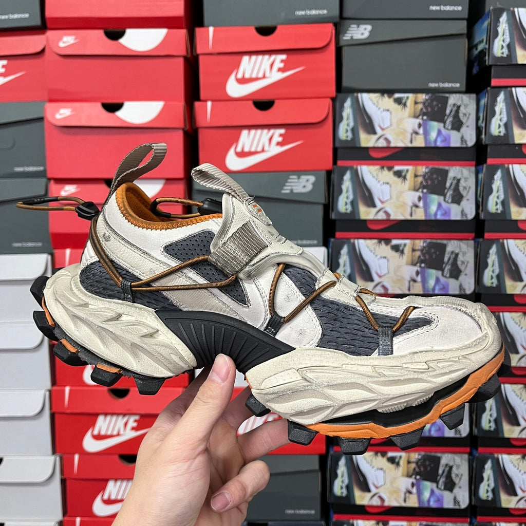 Balenciaga unisex chunky sneakers, light gray and black upper with orange outsole trim.