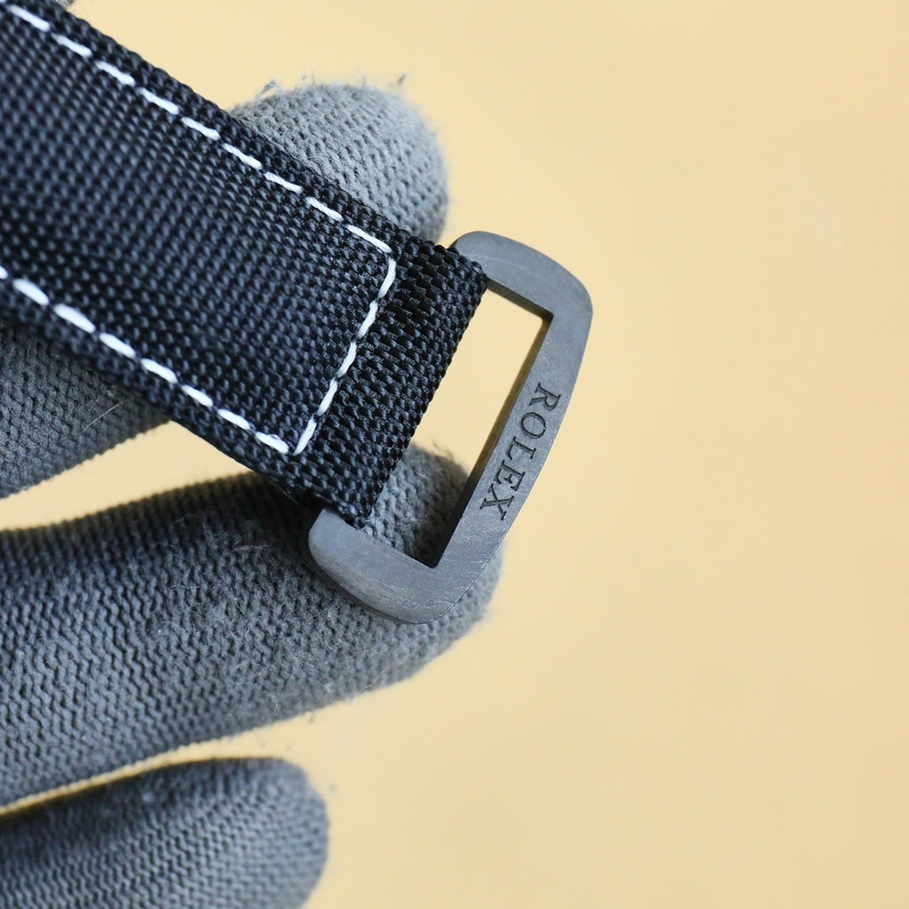 Rolex Daytona strap clasp with black fabric strap and metal buckle.
