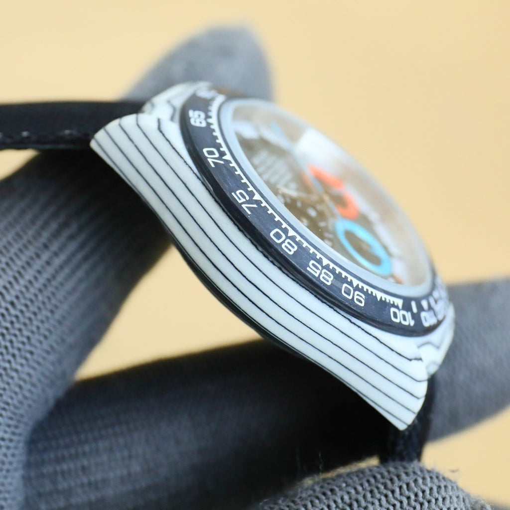 Rolex Daytona watch side view with engraved bezel and crown, on fabric strap.