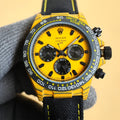 Rolex Daytona watch with yellow dial, black bezel, and black fabric strap.