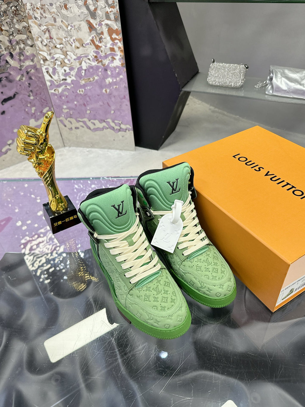 Green Louis Vuitton high-top sneakers with white laces and monogram detail, on box