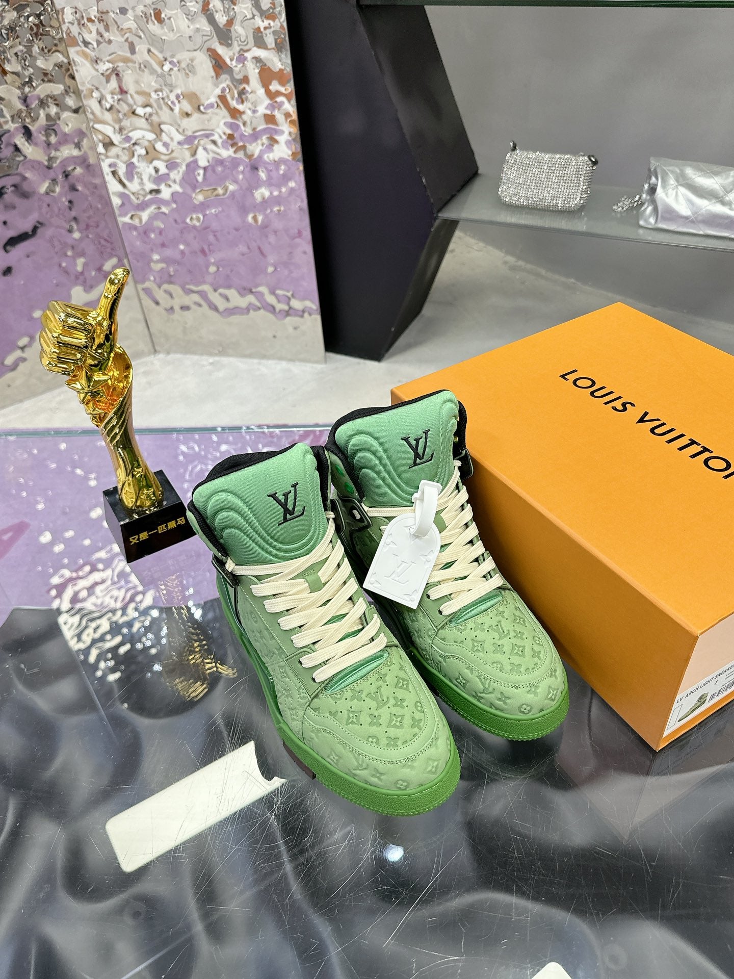 Green Louis Vuitton high-top sneakers with white laces and monogram detail, on box